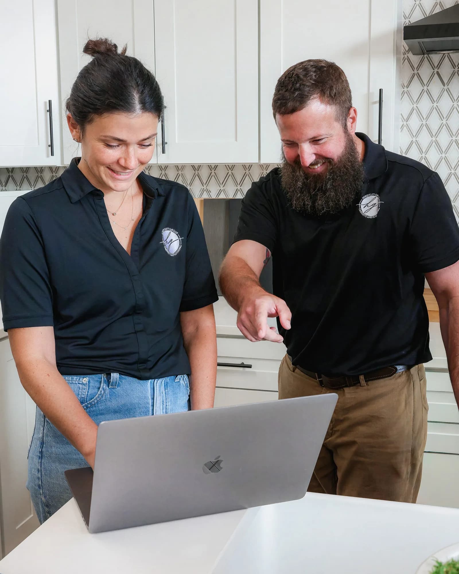 Lianna Honeycutt and Dylan Whitley of Honeycutt Group reviewing a project on a laptop in the showroom