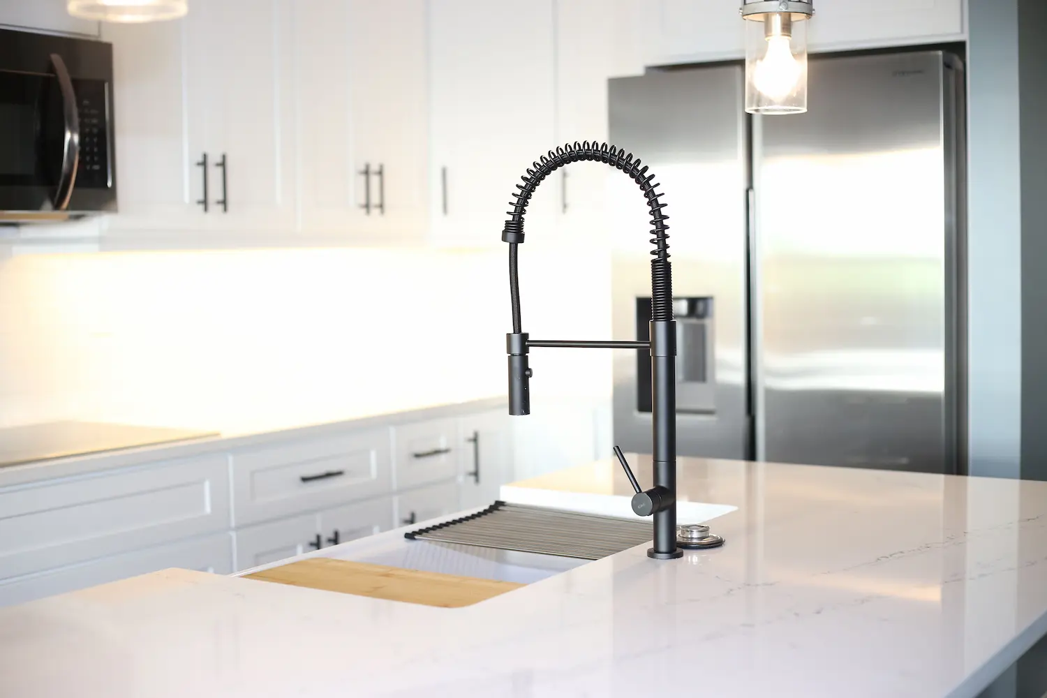 Contemporary kitchen island with quartz countertop and black industrial-style faucet