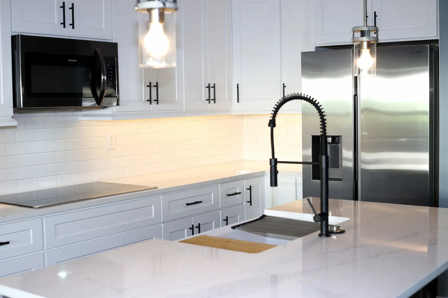 Quartz counter with undermount sink and white subway tile backsplash
