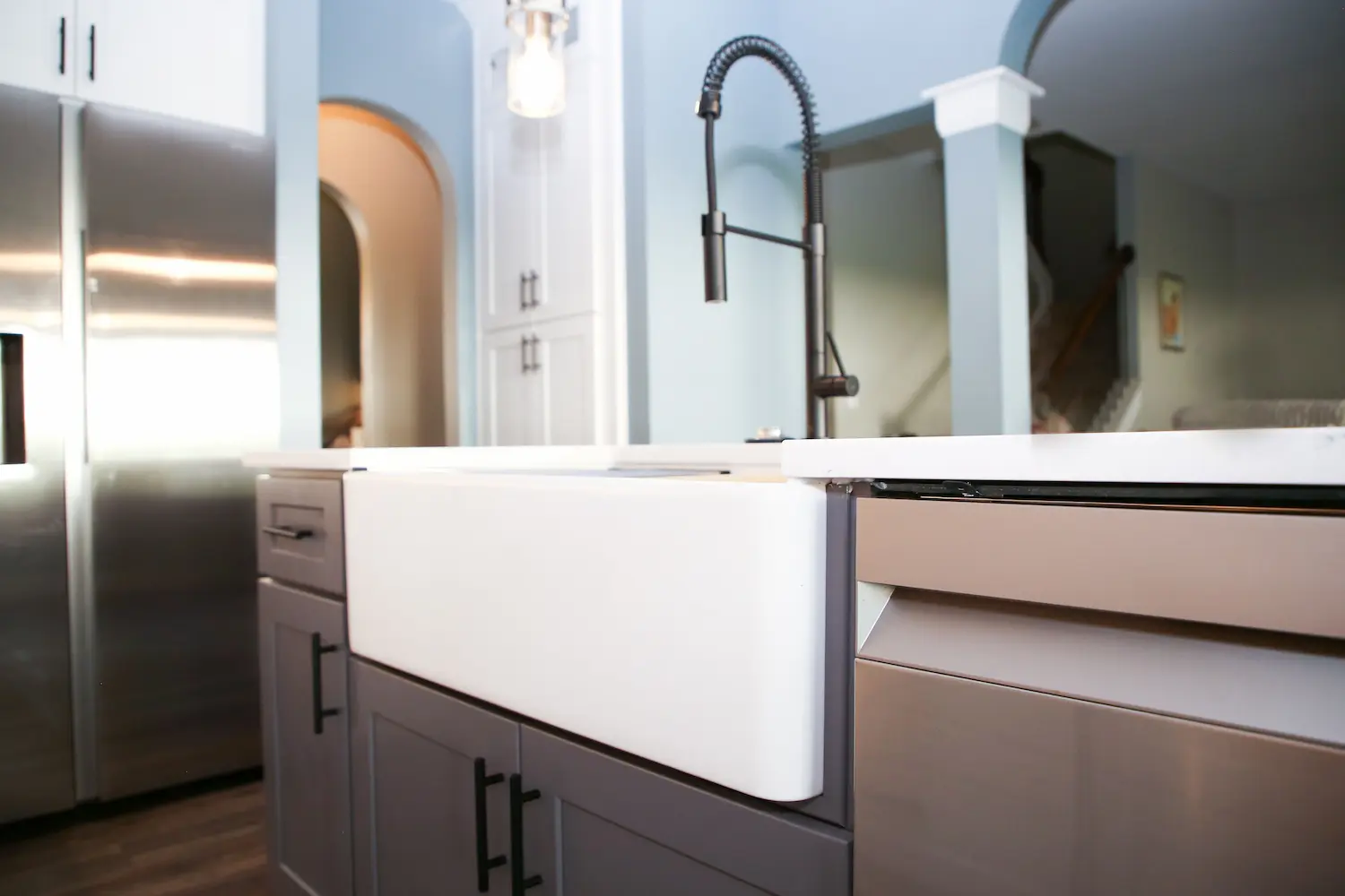 White farmhouse apron sink with black spring-neck faucet