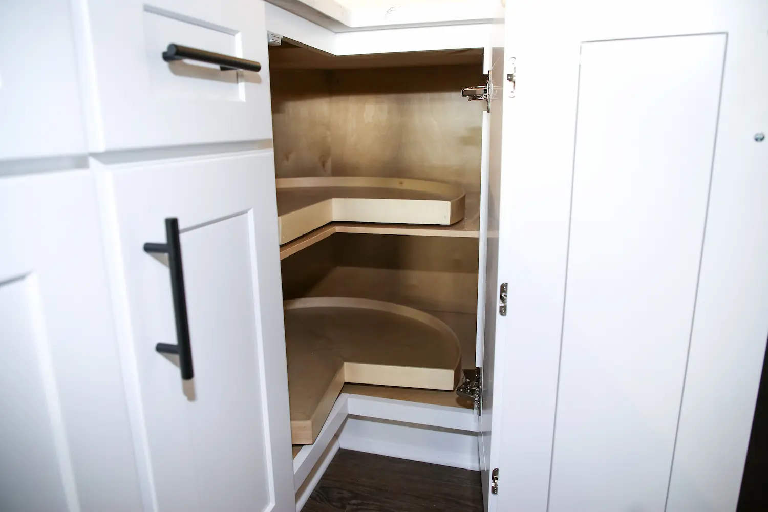 Open corner base cabinet fitted with curved lazy-susan shelving