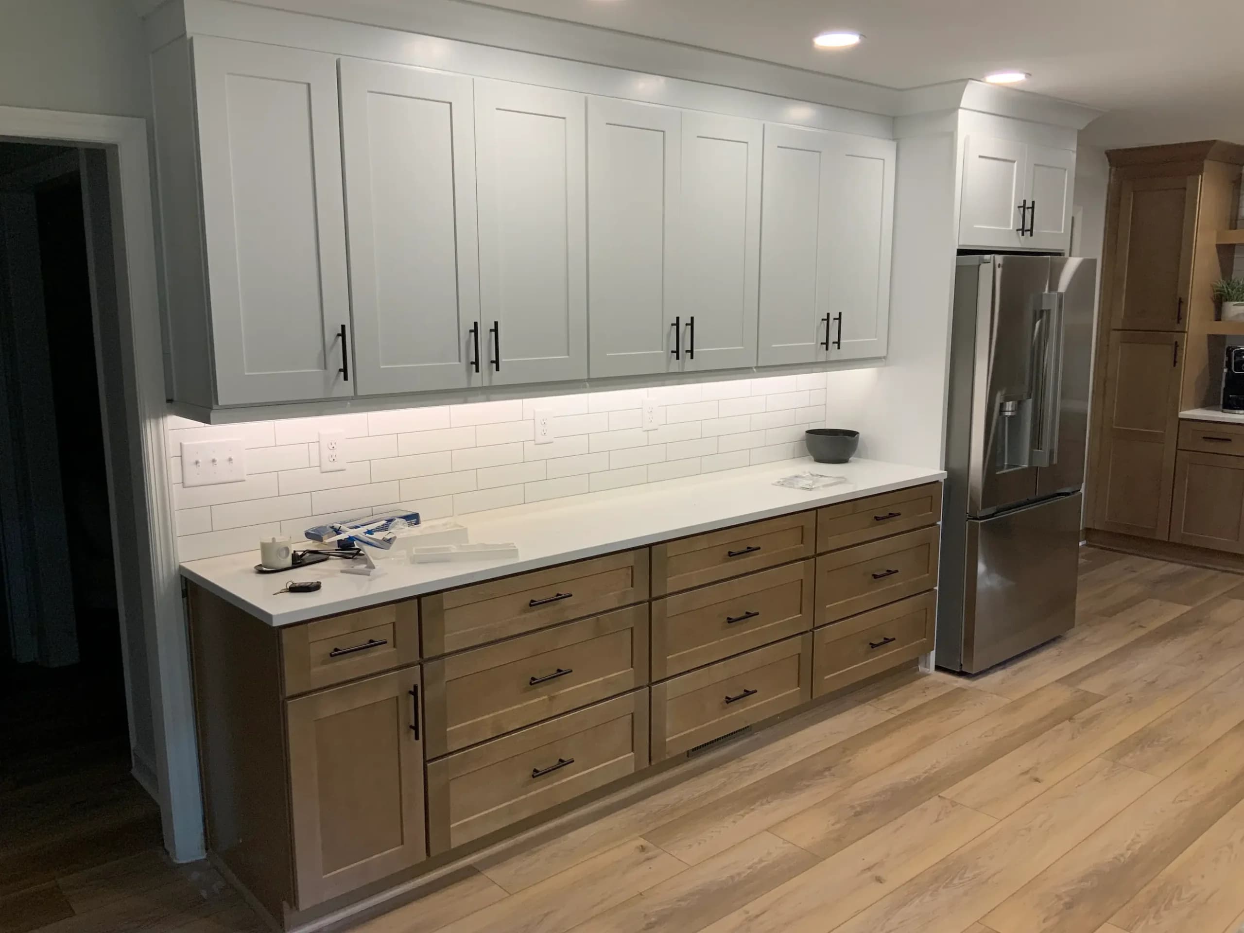White upper cabinets over wood lowers with subway tile backsplash