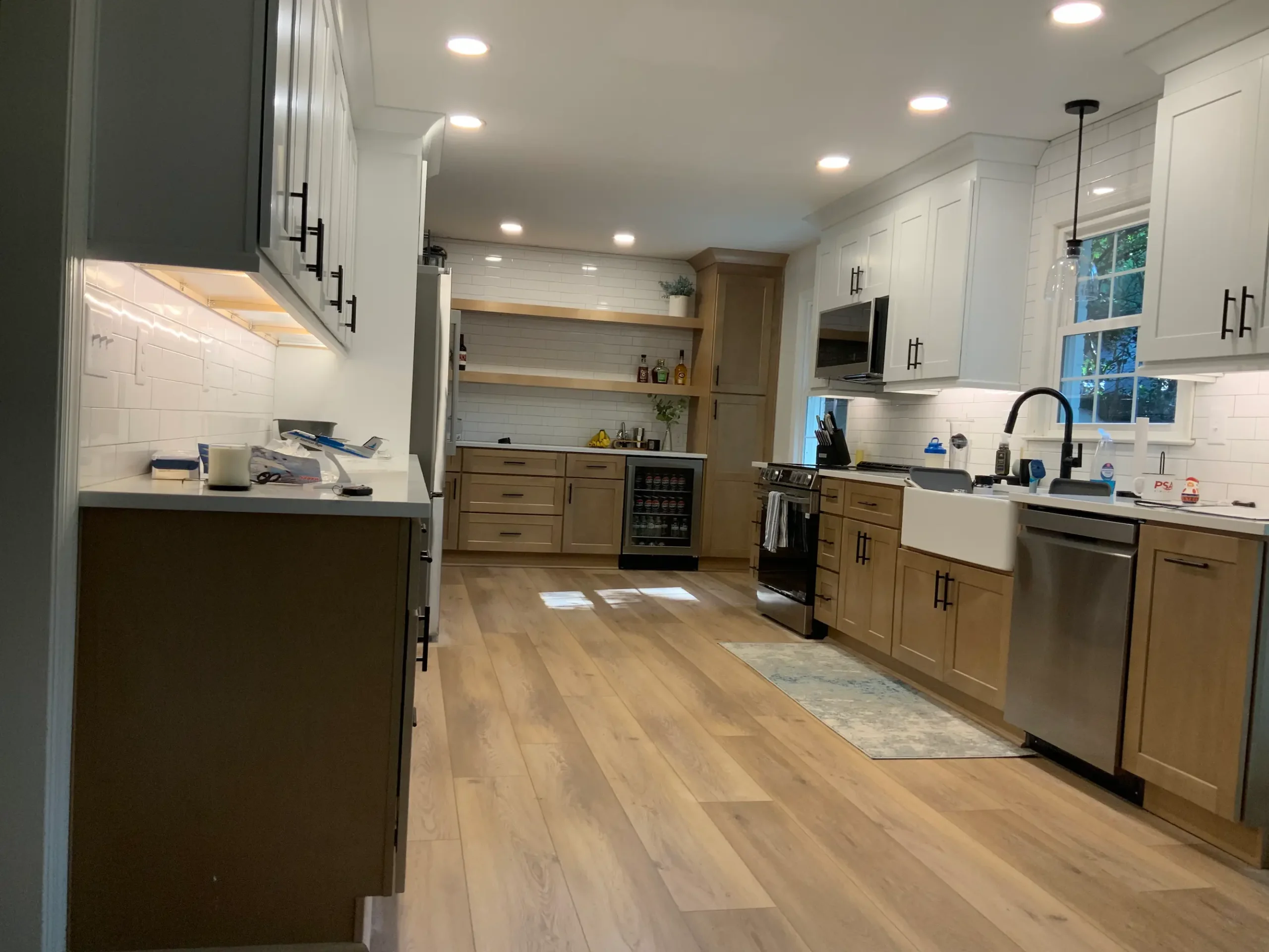 Light wood cabinets with open shelving and a farmhouse sink