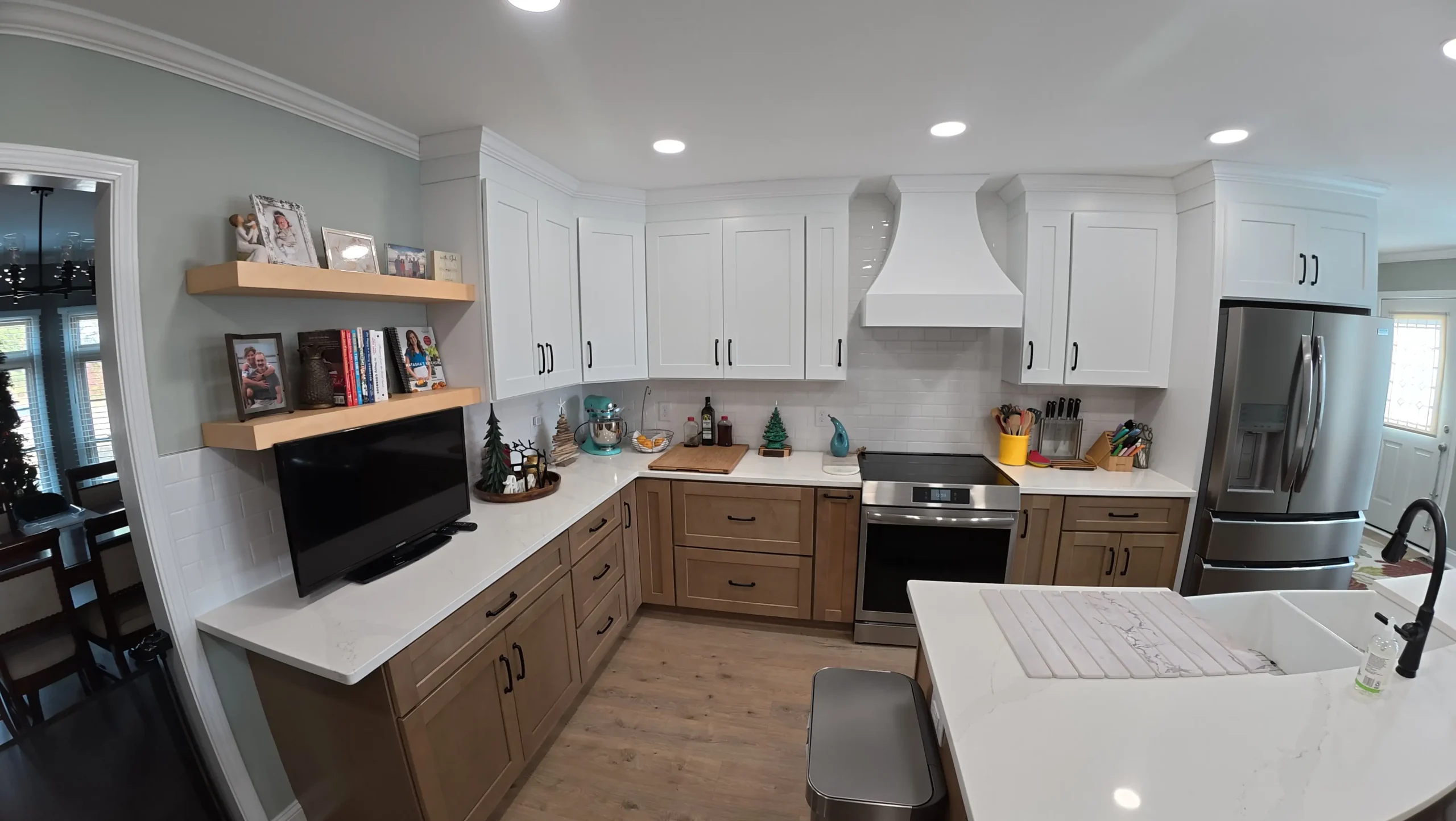 White plaster range hood and floating oak shelves above walnut cabinets
