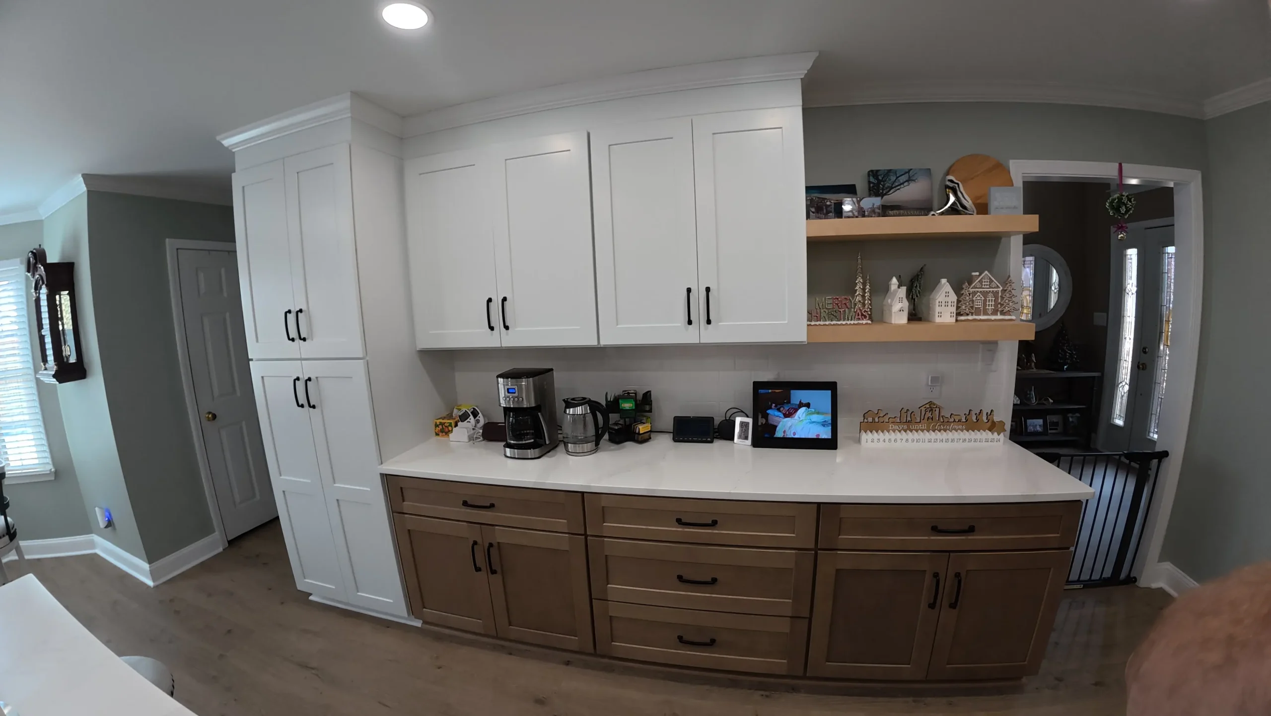 Coffee station on walnut cabinets below a floating oak shelf