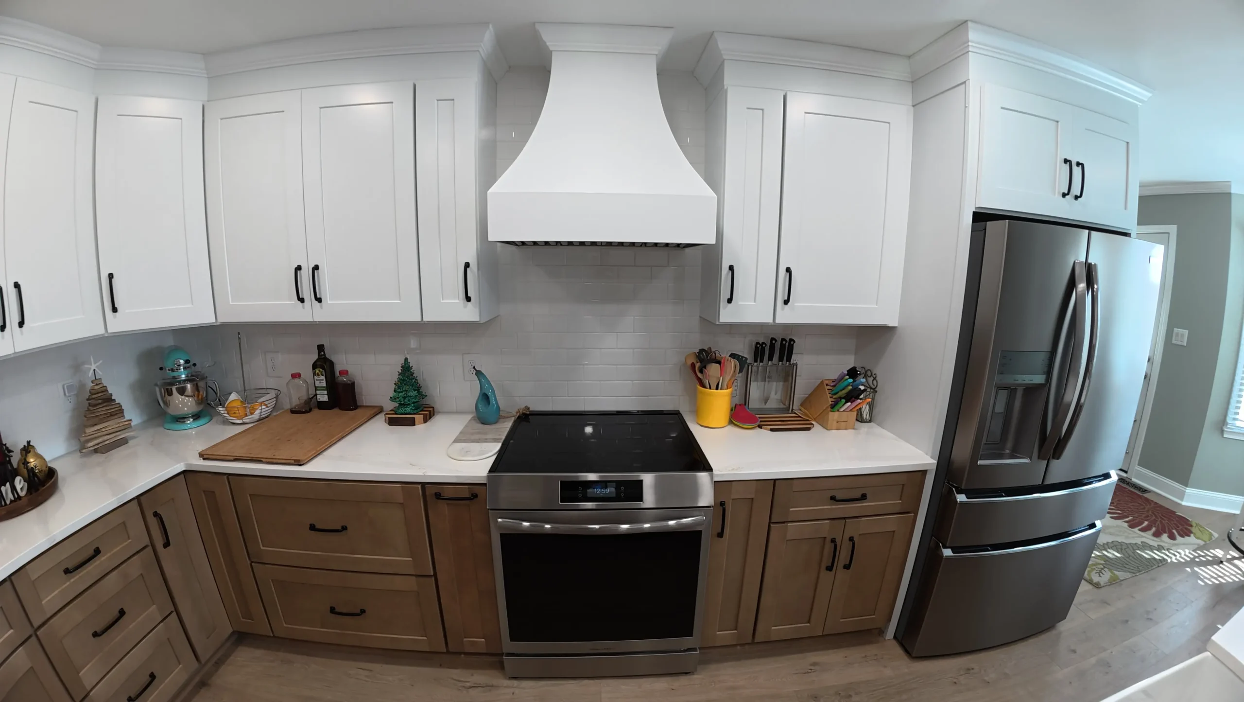 White range hood over a slide-in range with tile backsplash