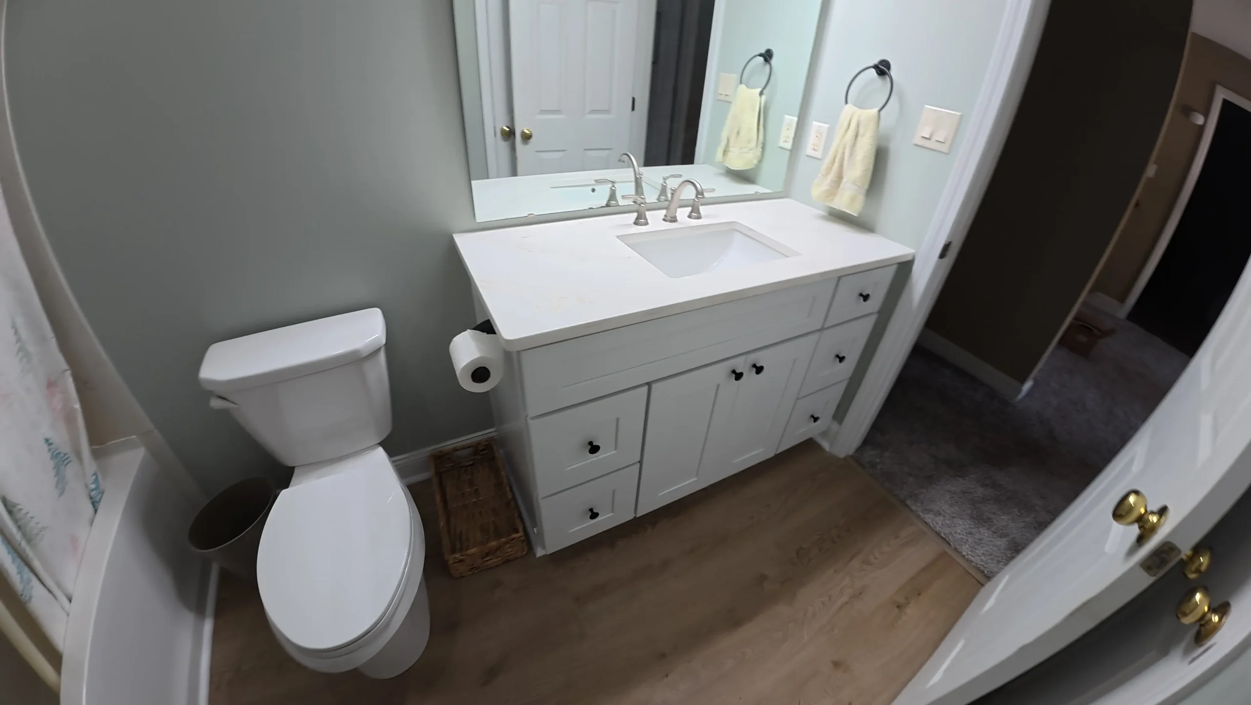 Remodeled bathroom vanity with framed mirror and white countertop