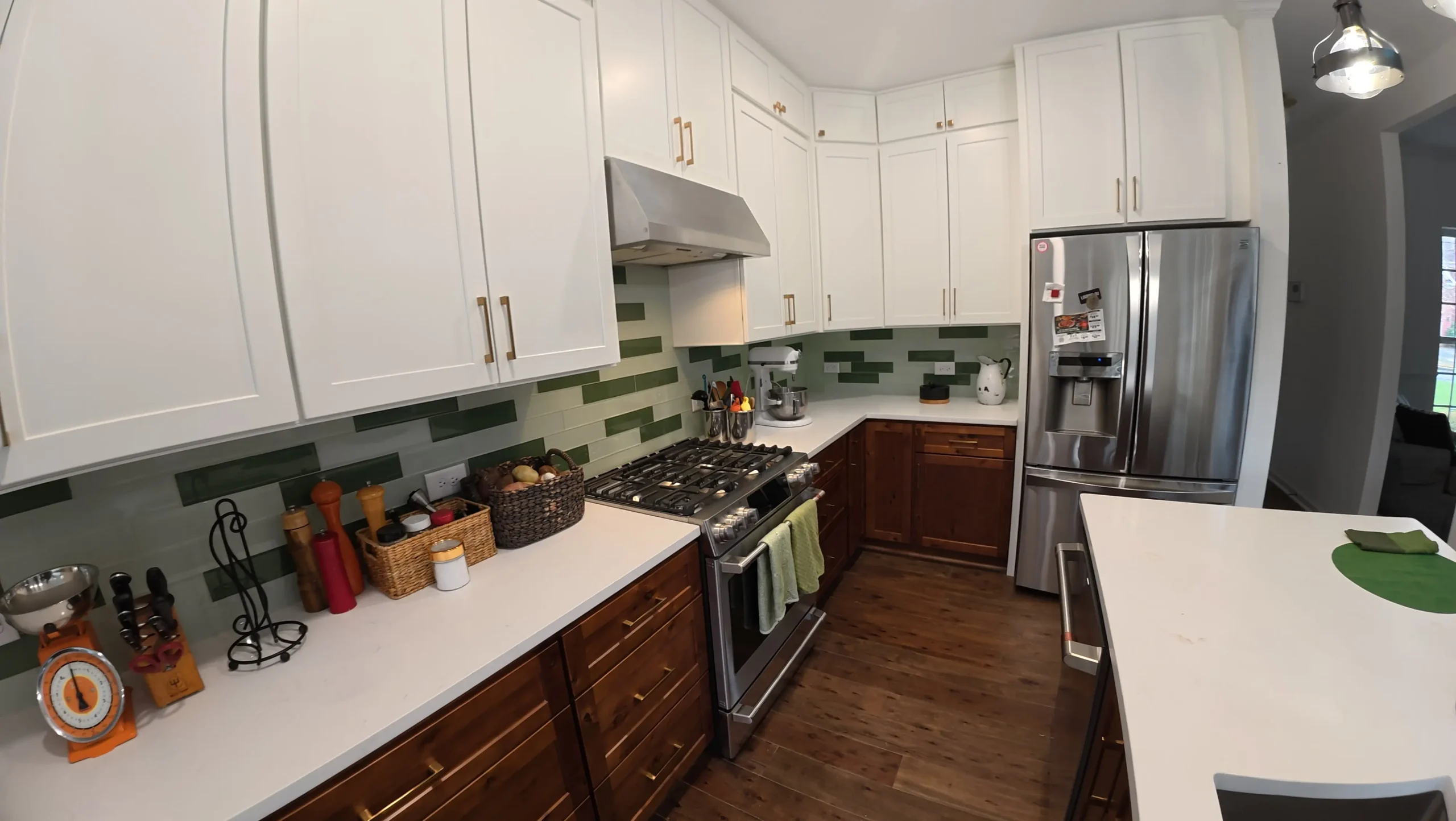 Brown base cabinets under white uppers with a gas range