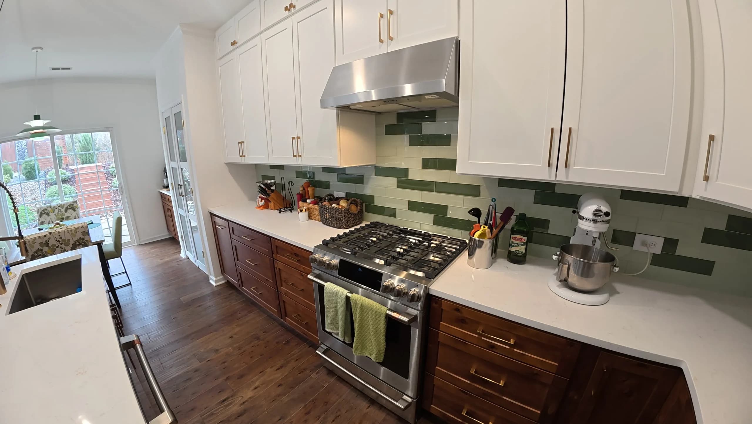 White uppers and brown lowers with a green glass tile backsplash