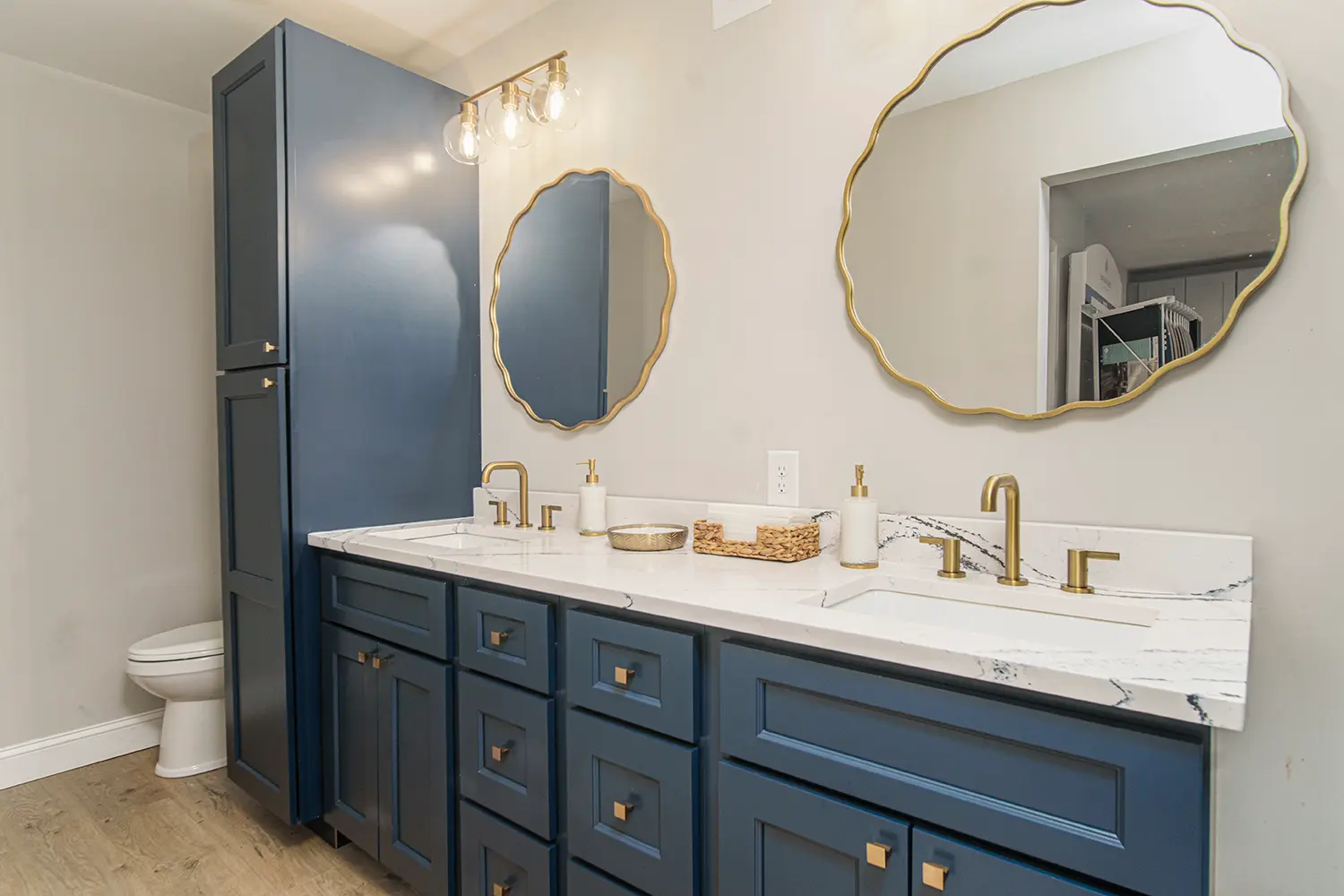 Honeycutt Group showroom bathroom display with blue cabinets and gold fixtures