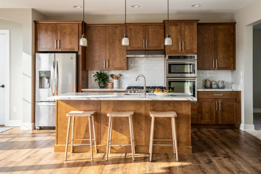 Beautifully remodeled kitchen in Charlotte NC featuring warm shaker cabinets, quartz countertops, and center island